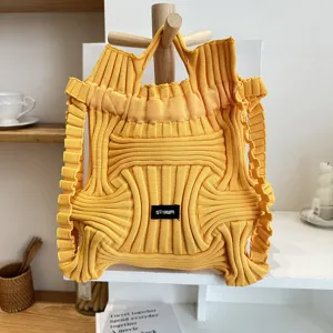 Detail of yellow pleated knitted handbag with unique structured designer style