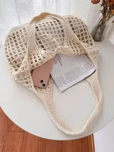 Vue détaillée de dessus d'un grand sac cabas en tricot crème montrant sa capacité