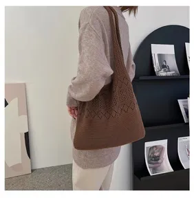 Detailed macro view of brown hollow knit shoulder bag with vintage style patterns on model