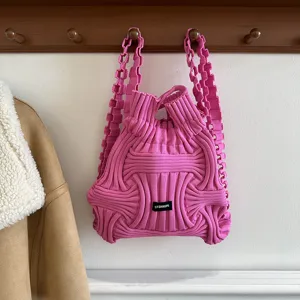 Detail view of a pink knitted woven dual-use backpack and handbag with unique texture.
