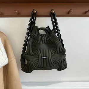 Close-up detail of a dark olive green knitted woven backpack featuring a unique textured design