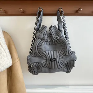 Detail view of a unique grey knitted braided backpack with a modern textured design.