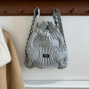 Detailed view of a grey knit woven backpack featuring a unique 3D geometric stripe design.