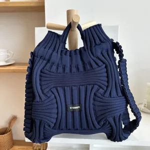 Macro view of a navy blue knitted dual-use backpack featuring a unique ribbed texture