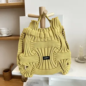 Detailed view of unique yellow niche design knitted handbag with ribbed texture and logo