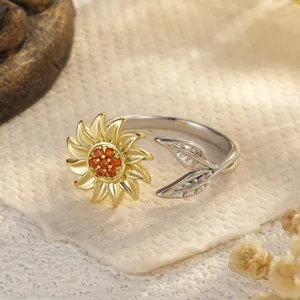 Gros plan d'une bague tournesol bicolore avec pierres oranges et détails