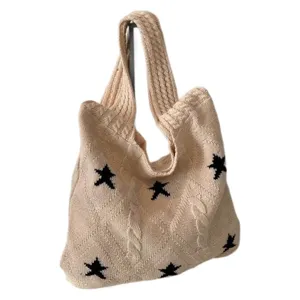 Minimalist beige knitted tote bag with black star patterns and cable knit texture