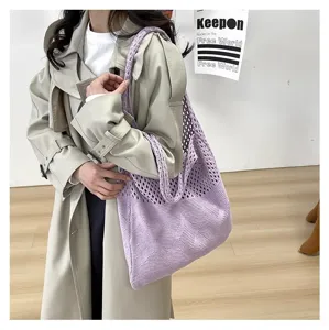 Detalle de un bolso tote de punto calado morado con patrones geométricos tejidos