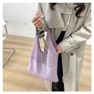 Detalle de un bolso tote de punto calado lavanda combinado con una gabardina beige muy elegante.