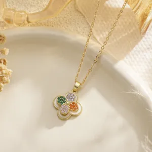 Close-up of rotatable four-leaf clover pendant with colorful gemstones on gold chain