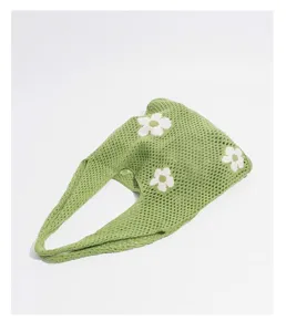 Vista detallada del bolso de ganchillo verde con estampados de margaritas blancas