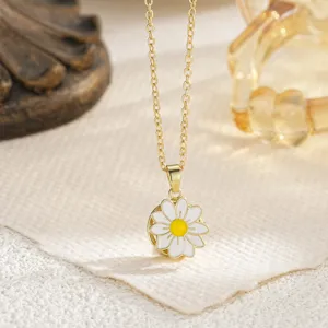 Close-up of a gold daisy necklace featuring a rotating white enamel flower pendant.