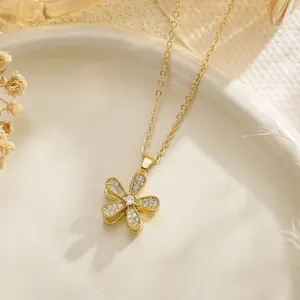 Detailed macro shot of a gold-plated rotating daisy flower pendant with clear crystals