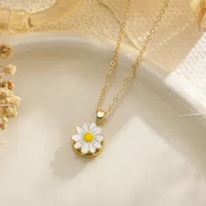 Close-up of rotating white daisy flower pendant on a dainty gold chain necklace