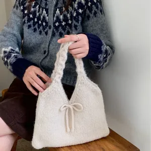 Trendy white knitted tote handbag with cute bow detail for casual autumn and winter outfits