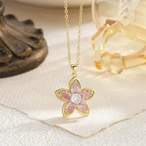 Close-up of elegant gold flower pendant necklace with pink and white gemstones