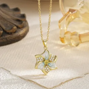 Detalle de un colgante de flor giratoria con esmalte blanco y gema amarilla brillante
