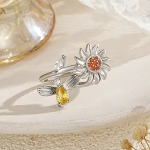 Détail macro d'une bague ouverte tournesol et abeille avec des cristaux jaunes