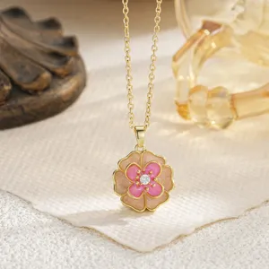 Detailed view of the camellia pendant necklace with pink enamel and zircon center