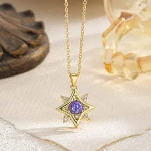 Detailed view of a gold-plated eight-pointed star pendant with purple center stone.