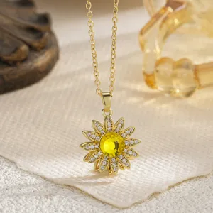 Macro view of rotating sunflower necklace with yellow crystal center and gold chain