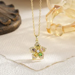 Detailed view of gold necklace with multi-color gemstone flower pendant.