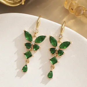 Close-up of vintage butterfly earrings with emerald green zircons and gold plating