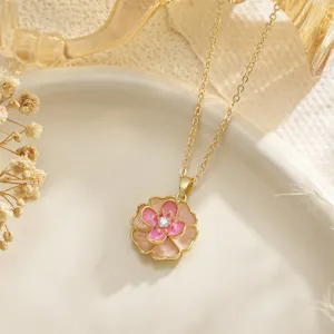Close-up of pink enamel flower necklace with zircon pendant on a ceramic plate