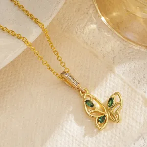 Macro view of a gold-plated hollow butterfly pendant necklace with emerald green zircon stones