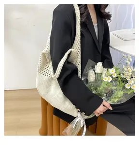 Mujer elegante con un bolso tote de punto calado blanco con un diseño de diamantes