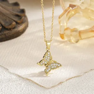 Close-up of gold butterfly pendant necklace with sparkling white cubic zirconia stones.