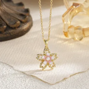 Close-up view of elegant pink enamel flower pendant with sparkling zircon and pearl details