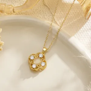 Detailed close-up view of a golden rotatable clover flower pendant necklace with an opal center