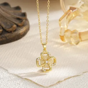 Detailed macro view of a rotating golden four-leaf clover pendant with cat's eye stones.