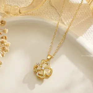 Close-up of golden rotating four-leaf clover pendant necklace with opal inlays