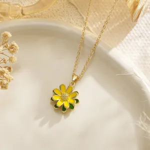 Detailed macro shot of a yellow enamel daisy pendant hanging from a gold-tone necklace