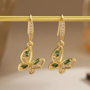 Elegant close-up of vintage hollow butterfly earrings with emerald green zircon stones