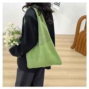 Detalle de un bolso de malla de punto verde vibrante combinado con una elegante chaqueta negra.
