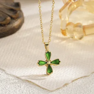 Detailed close-up of a delicate gold chain necklace with a green enamel floral pendant