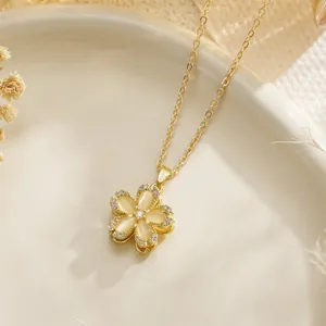 Close-up of rotatable gold flower pendant necklace with opal-like stones and crystals