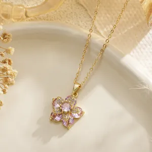Close-up detail of a pink gemstone five-petal flower pendant necklace in gold finish