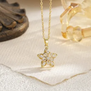 Detailed macro view of a gold five-petal flower pendant necklace with clear stones.