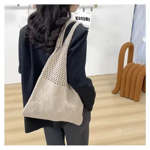 Vista detallada de un bolso de punto calado beige de estilo bohemio sobre una americana