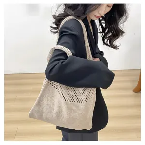 Detalle de bolso tote de punto beige con diseño calado y textura de tejido fino