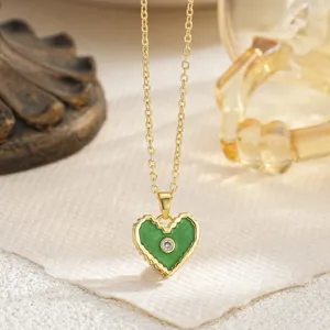 Macro view of a green enamel heart pendant necklace with a sparkling zircon center.