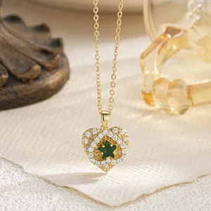 Elegant gold heart pendant necklace with green star and zircon inlays on a warm background