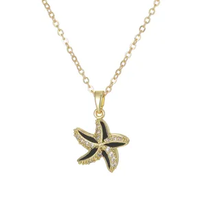 Gold starfish pendant necklace with black enamel and sparkling zircon stones
