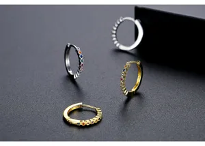 Detail von minimalistischen Gold- und Silber-Creolen mit bunten Zirkon-Edelsteinen