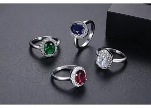 Vista detallada de elegantes anillos de circonita ovalada con halo en varios colores