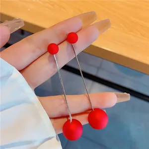 Elegant long drop earrings featuring matte red beads and thin silver-tone metal chains